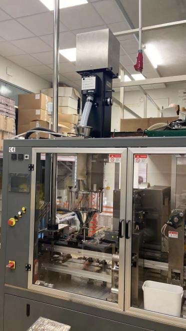 Enclosed coffee capsule auger filling assembly