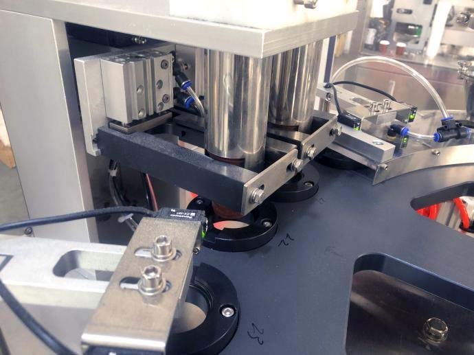 CF140 capsule feeding and drop station beside the rotary turntable