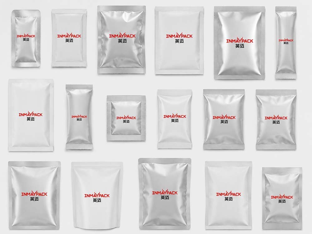 Various sizes of silver foil pouches, stick packs, and flat sachets with INMAYPACK logo