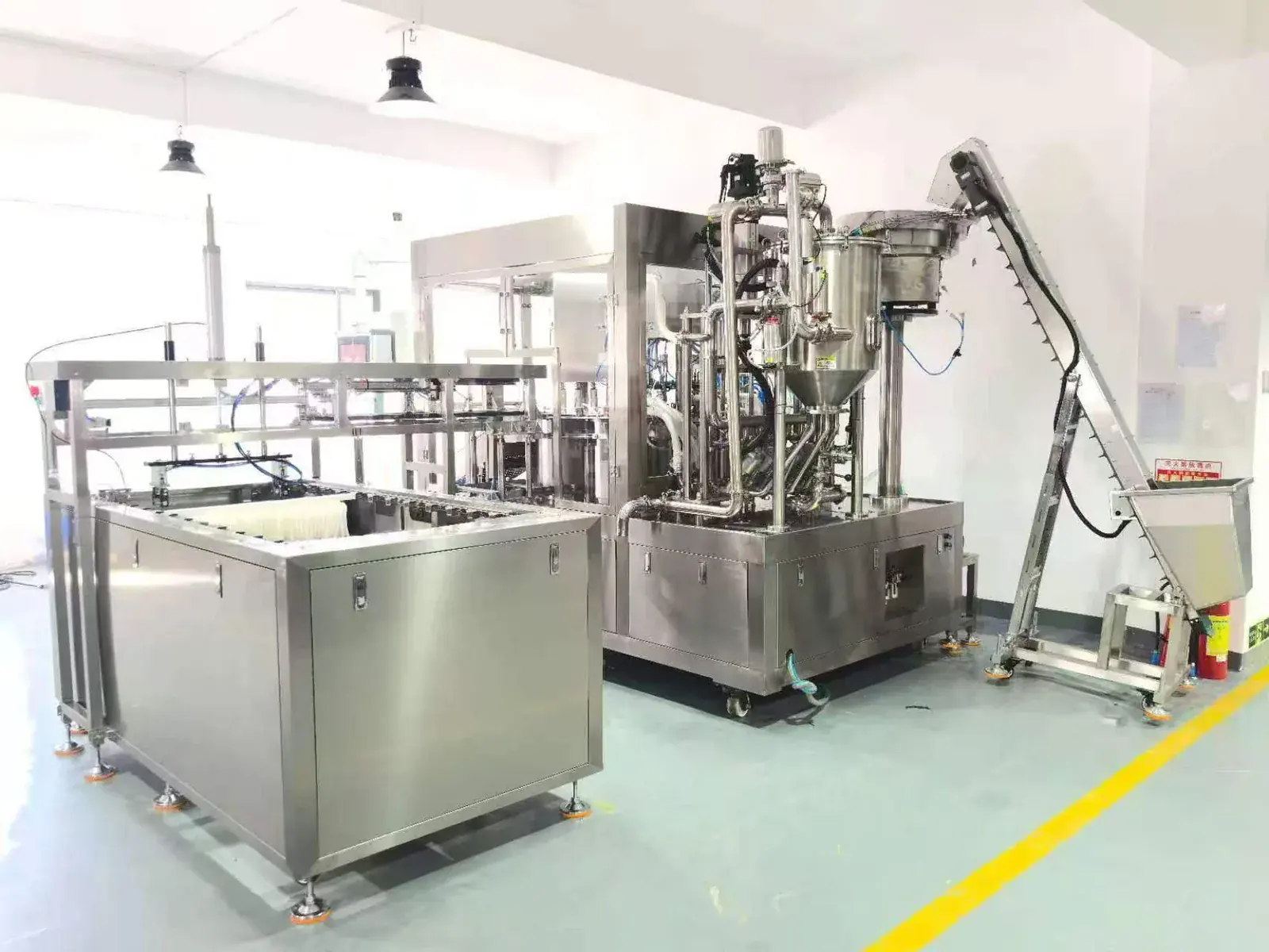 Cap feeding elevator beside a spout pouch filling and capping machine